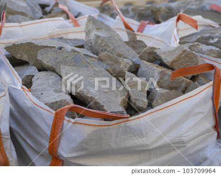 Construction mounds. Large white bag with handles filled with various types of pebbles or cobblestones 103709964