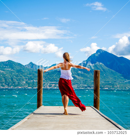 Woman in red dress staying at the lake Woman in red dress staying at the lake 103712025