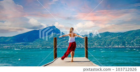 Woman in red dress staying at the lake Woman in red dress staying at the lake 103712026