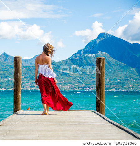 Woman in red dress staying at the lake Woman in red dress staying at the lake 103712066