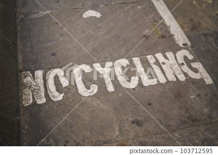 No cycling written on asphalt of pedestrian pathway tunnel. 103712595