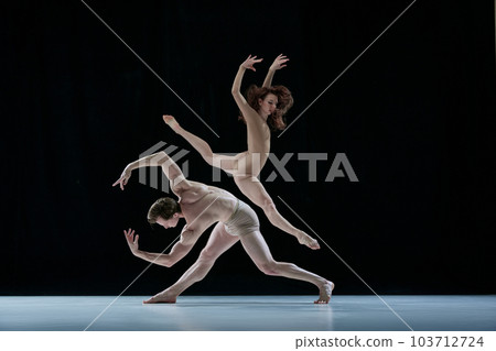 Graceful, artistic couple, man and woman, professional ballet dancers performing against black studio background Graceful, artistic couple, man and woman, professional ballet dancers performing against black studio background 103712724