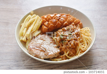 grilled pork steak dressing gravy sauce with French fries and cos lettuce salad couple sausage on plate 103714031