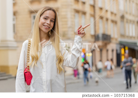 Happy woman pointing empty place advertising area for commercial text copy-space in city street Happy woman pointing empty place advertising area for commercial text copy-space in city street 103715368