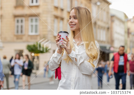 Happy woman girl enjoying drinking morning coffee hot drink, relaxing, taking a break in city street 103715374