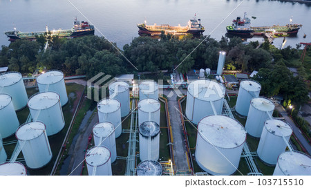 Aerial view oil storage tanks and tanker in river at night, Aerial view of oil storage tanks and tanker ship in the port town, Tanker ship in the port. 103715510