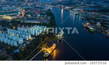 Aerial view oil storage tanks and tanker in river at night, Aerial view of oil storage tanks and tanker ship in the port town, Tanker ship in the port. 103715516