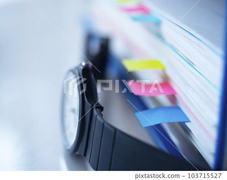 桌上的藍色文件和手錶 103715527