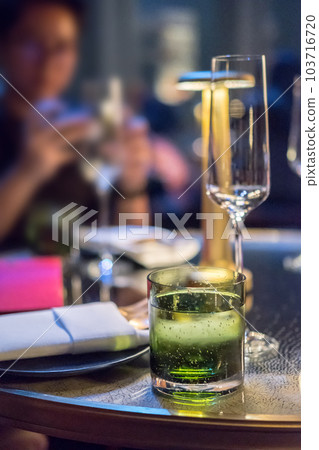 Cocktail glass with plate and table lamp on the table 103716720