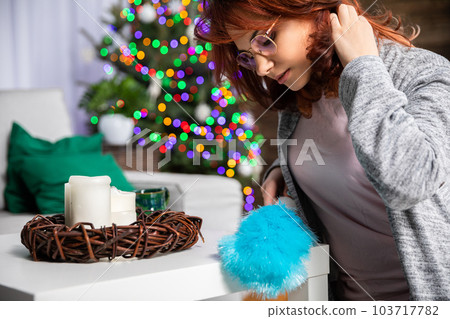 The girl cleans the dust off the furniture by hand with a special brush. The girl cleans the dust off the furniture by hand with a special brush. 103717782