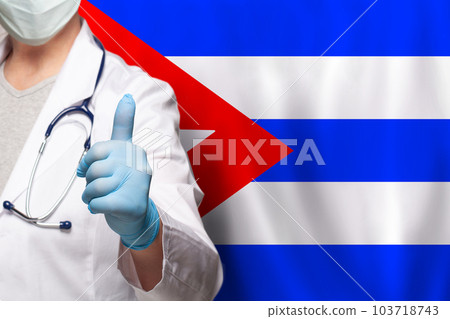 Cuban doctor's hand showing thumb up positive gesture on flag of Cuba background 103718743