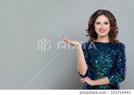 Happy nice fashionable model woman showing empty open hand palm on grey banner background 103719441