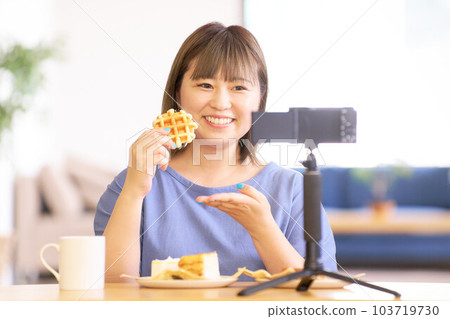 A young woman introducing sweets to the camera 103719730