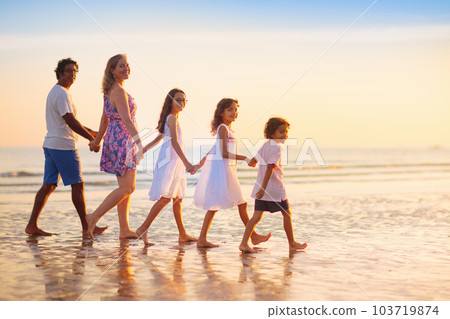 Family walking on tropical beach at sunset Family walking on tropical beach at sunset 103719874