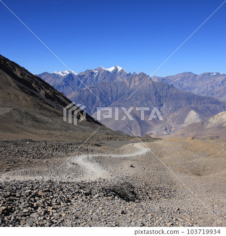 Foot path leading from Thorong La mountain pass towards Muktinath, Nepal. 103719934