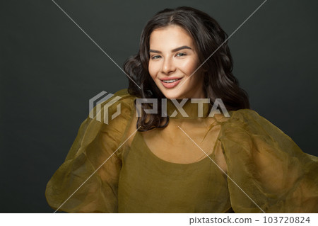 Happy smiling brunette model woman with dark hair against black studio wall background 103720824