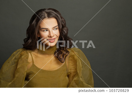 Cheerful fashion model woman with makeup and dark hair against black studio wall background 103720829