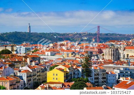 Lisbon famous view from Miradouro dos Barros tourist viewpoint over Alfama old city district, 25th of April Bridge and Christ the King statue. Lisbon, Portugal. Lisbon famous view from Miradouro dos Barros tourist viewpoint over Alfama old city district, 25th of April Bridge and Christ the King statue. Lisbon, Portugal. 103725427