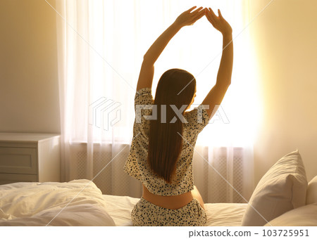 Young woman stretching on bed at home. Lazy morning 103725951