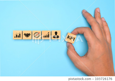 Key performance indicator, Businessman holding wooden cube with KPI Key performance indicator, Businessman holding wooden cube with KPI 103726176