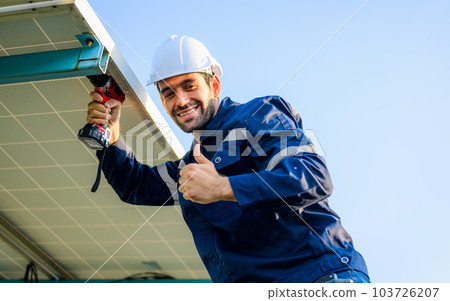 Male technician worker installing solar panels at solar cell farm 103726207