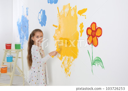 Little child painting wall with roller brush indoors 103726253
