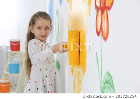 Little child painting wall with roller brush indoors 103726254