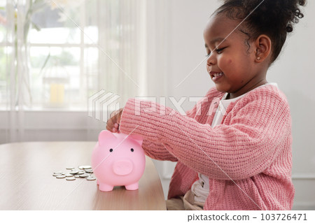 Little girl putting coin of cash into ceramic piggy bank Little girl putting coin of cash into ceramic piggy bank 103726471