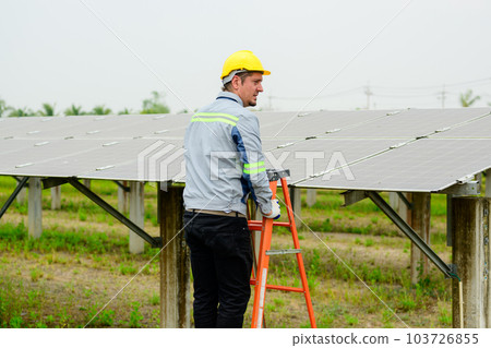 Maintenance technician checking solar panels on solar cell farm Maintenance technician checking solar panels on solar cell farm 103726855