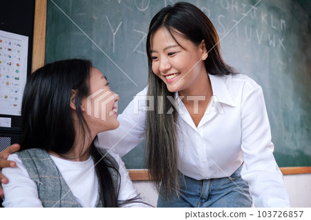 Happy student studying with teacher in classroom at school Happy student studying with teacher in classroom at school 103726857