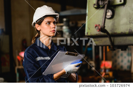 Confident female technician engineer worker checking and inspecting machine Confident female technician engineer worker checking and inspecting machine 103726974