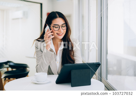 Confident businesswoman enjoying with work at office 103727032