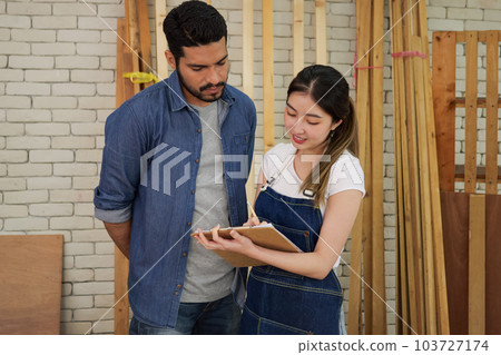 Couple of carpenters making furniture in wood workshop Couple of carpenters making furniture in wood workshop 103727174