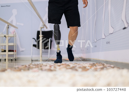 Athlete man with prosthetic leg walking at health care center 103727448