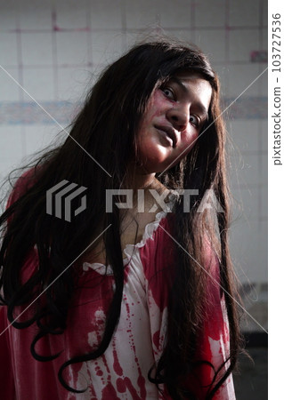 Scary woman in white dress with bloodstain after murder, Halloween concept Scary woman in white dress with bloodstain after murder, Halloween concept 103727536