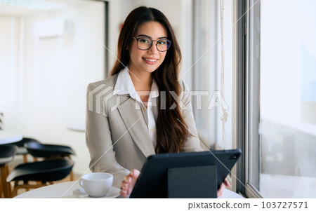 Confident businesswoman smiling to camera and working at office 103727571