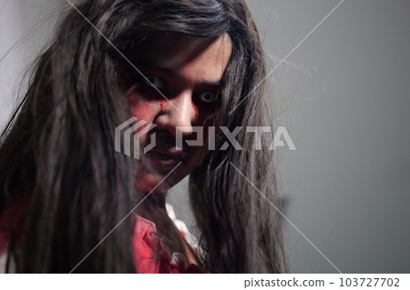Scary woman in white dress with bloodstain after murder, Halloween concept 103727702