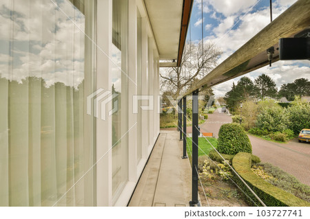 an outside view from inside the house, looking out to the street and trees in the distance are white clouds 103727741