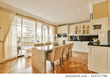 a dining room with wood flooring and an open door leading out to the kitchen, living room and dining area 103727796