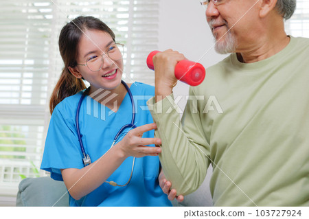 Elderly adult exercising by lifting weights at home 103727924