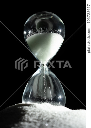 Hourglass add more sand of time on white sand over black background. White hourglass show more time Deadline extended time management hope concept hour glass, life clock passing by Hourglass add more sand of time on white sand over black background. White hourglass show more time Deadline extended time management hope concept hour glass, life clock passing by 103728657