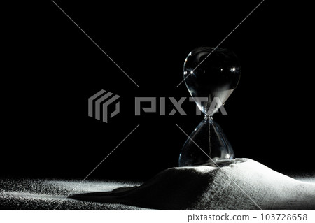 Hourglass add more sand of time on white sand over black background. White hourglass show more time Deadline extended time management hope concept hour glass, life clock passing by 103728658