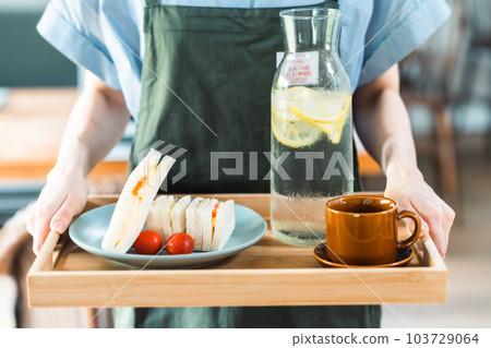 A young woman working at a fashionable cafe in the suburbs faceless 103729064