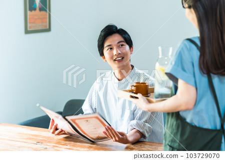 Male and female part-time workers ordering from paper menus Male and female part-time workers ordering from paper menus 103729070
