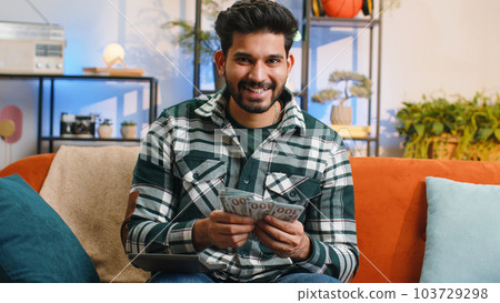 Rich indian man counting money cash and use calculator, calculate domestic income earnings at home Rich indian man counting money cash and use calculator, calculate domestic income earnings at home 103729298