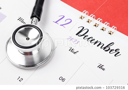 Stethoscope medical and December 2023 desk calendar on the red background Stethoscope medical and December 2023 desk calendar on the red background 103729316