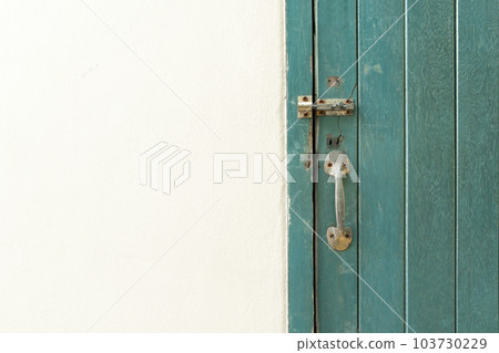 The Closed padlock hangs on the green color wooden door and wall. The Closed padlock hangs on the green color wooden door and wall. 103730229