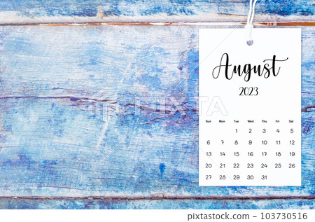 The August 2023 calendar page hanged with white rope on old blue wooden background. The August 2023 calendar page hanged with white rope on old blue wooden background. 103730516