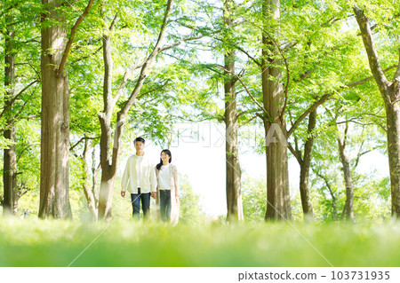 Portrait of man and woman walking in park 103731935