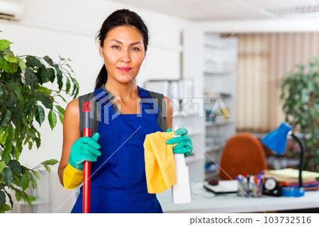 Woman wiping office floor with mop Woman wiping office floor with mop 103732516